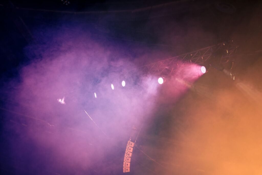 Por que sincro producciones, produccion de eventos antioquia, alquiler equipos, sonido medellin Dynamic stage scene with colorful lighting and fog, creating a vibrant atmosphere.