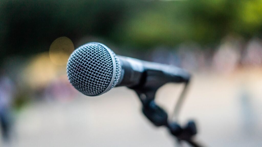 Por que sincro producciones, produccion de eventos antioquia, alquiler equipos, sonido medellin Soft focus of contemporary microphone on holder placed on stage during performance in park