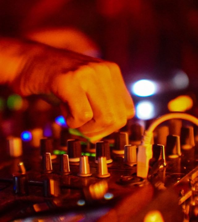 Vibrant DJ performance capturing the essence of night parties in Mexico City with dynamic lighting and music equipment.